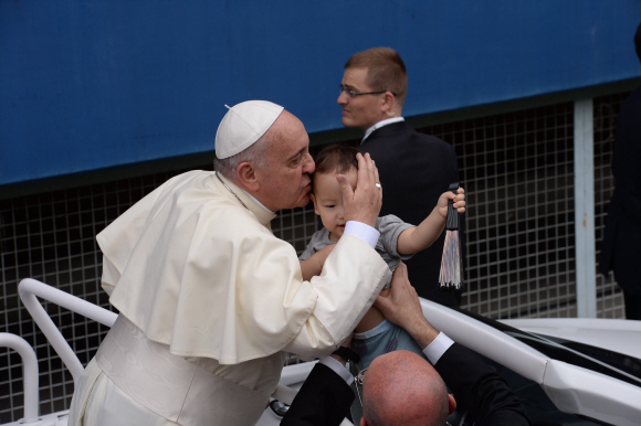 프란치스코 교황이 대전 월드컵 경기장에 입장 중 신원 미상 아이의 이마에 축복의 키스를 하고있다.  사진공동취재단