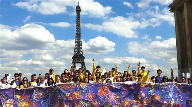 ‘희망나비’ 회원들이 지난 6월 27일 프랑스 파리 에펠탑 앞에서 파리시민, 전 세계 관광객들과 함께 각양각색의 나비를 그려 만든 걸개그림을 펼쳐 들고 기뻐하고 있다. 이 걸개그림은 현재 서울 을지로4가 지하보도 벽면에 전시돼 있다. 희망나비 제공