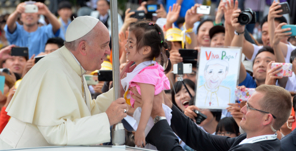 프란치스코 교황이 방한 나흘째인 17일 충남 서산시 해미읍성을 찾아 아시아 청년대회 폐막미사를 집전하기위해 입장하며 한 아이에게 축복을 내려주고 있다 .  서산 사진공동취재단
