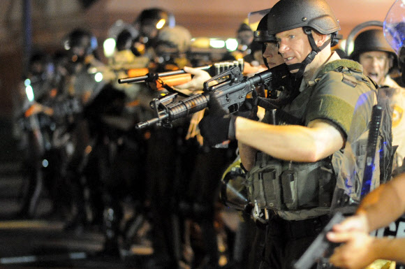 중무장한 미국 경찰들이 18일(현지시간) 미주리주 퍼거슨에서 흑인 청년에게 총을 쏴 숨지게 한 경찰을 규탄하는 시위대를 진압하기 위해 총을 겨누고 있다. 퍼거슨 AFP 연합뉴스