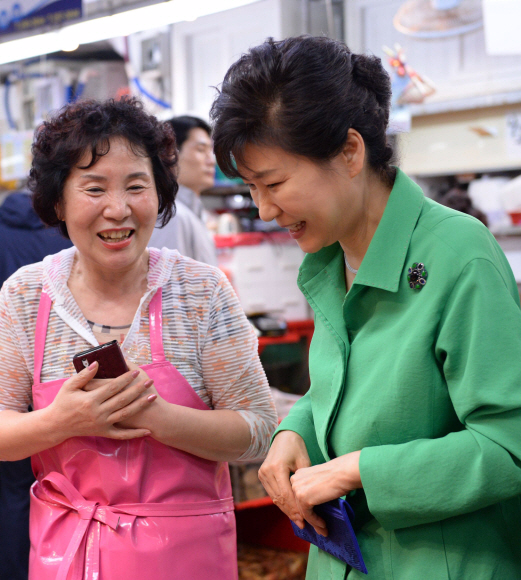 박근혜 대통령이 22일 부산 남포동 자갈치시장을 방문, 상인과 이야기를 나누며 수산물을 고르고 있다. 청와대사진기자단