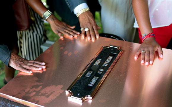흑인 청년 마이클 브라운의 장례식이 열린 25일(현지시간) 미국 미주리주 세인트루이스의 한 침례교회에서 유족들이 브라운의 관이 묻힌 묘지 표면을 어루만지고 있다. 세인트루이스 AP 연합뉴스