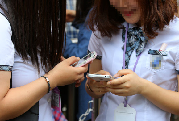 서울 한 놀이공원에서 스마트폰을 사용하는 여학생들의 모습. 연합뉴스
