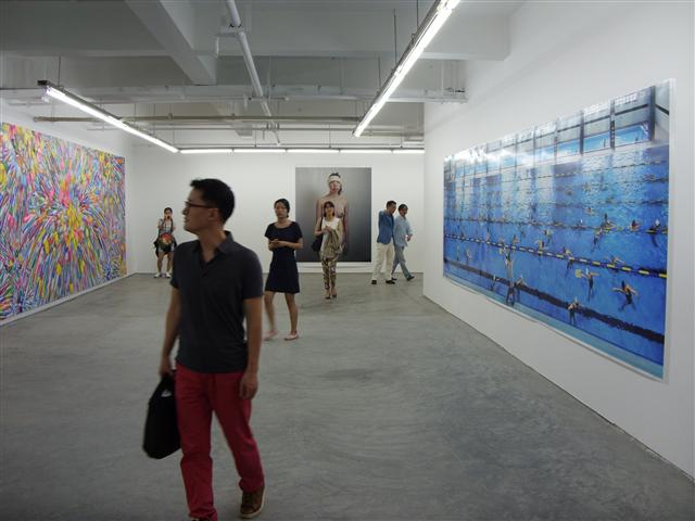 천쯔징 관장이 한국의 참여 작가들을 소개하고 있다. 세대를 아우르는 한국 현대미술 작가들의 작품을 미술 관계자들이 둘러보고 있다.