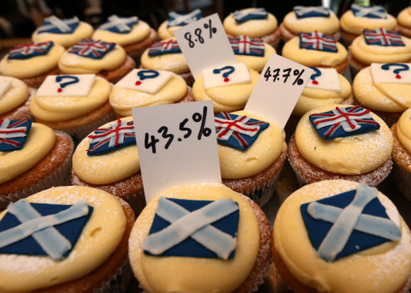 17일(현지시간) 스코틀랜드 에든버러의 한 빵가게에 진열된 미니 케이크들. 이 가게 주인은 스코틀랜드 독립투표 결과가 궁금해 200일 동안 영국기, 스코틀랜드기, 물음표가 그려진 세 가지 종류의 케이크를 만들어 팔았다. 그 결과 독립 반대가 47.5%로 독립 찬성(45.5%)보다 앞섰다. 에든버러 AP 연합뉴스