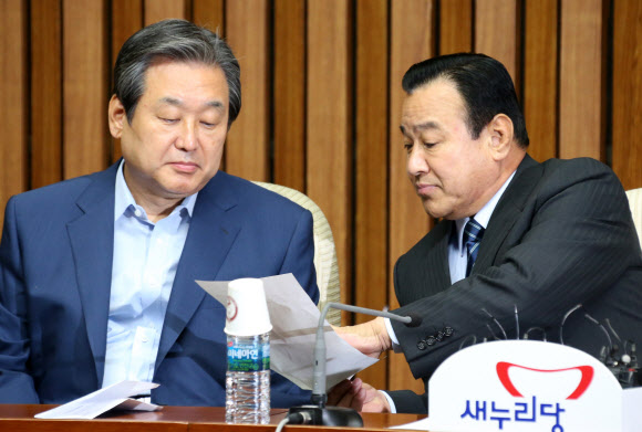 새누리당 김무성 대표(왼쪽)와 이완구 원내대표가 19일 국회에서 열린 주요당직자회의에서 대화하고 있다.  연합뉴스