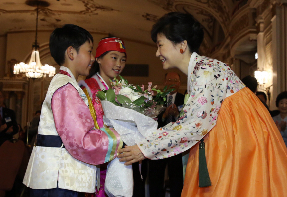 캐나다를 국빈방문한 박근혜 대통령이 21일 오전(한국시각) 오타와에 있는 한 호텔에서 열린 동포만찬간담회에 참석해 화동들에게 꽃다발을 받고 있다. 이호정 기자 hojeong@seoul.co.kr