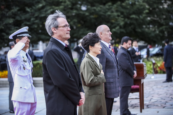 캐나다를 국빈방문중인 박근혜 대통령이 22일 오전(현지시간, 한국시간 23일 오전) 수도 오타와의 의회 의사당 부근에 있는 국립전쟁기념비를 찾아 헌화하고 참배했다. 이 기념비는 한국전쟁과 1,2차대전 참전용사들을 기리기 위해 1982년에 세워졌다. 왼쪽부터 데이빗 채터슨 주한 캐나다대사, 박 대통령, 줄리앙 환티노 캐나다 보훈부 장관. 이호정 기자 hojeong@seoul.co.kr