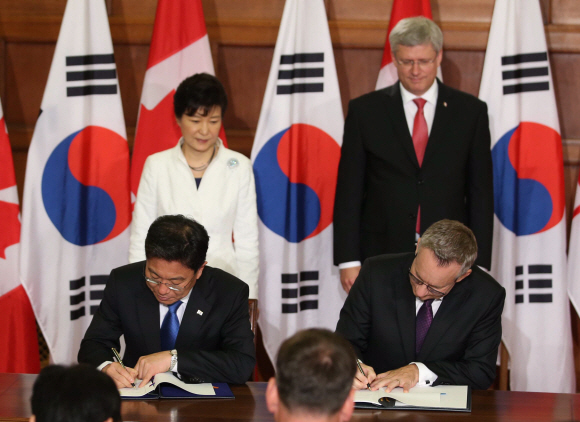 23일 오전(한국시각) 박근혜 대통령이 캐나다 연방의회에서 스티븐 하퍼 캐나다 총리와 한-캐나다 FTA에 서명한 윤상직 산업통상자원장관(왼쪽)과 캐나다의 에드 패스트 통상장관과 악수하는 모습을 지켜보고 있다.  이호정 기자 hojeong@seoul.co.kr