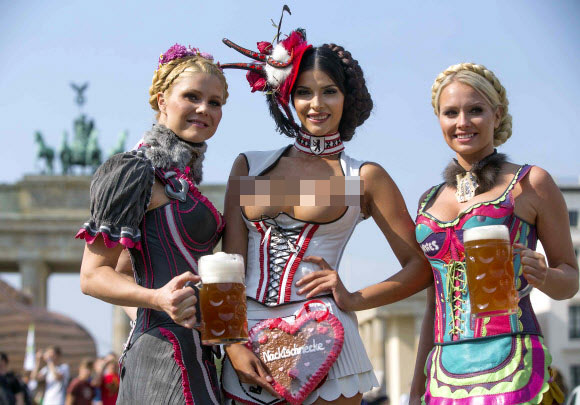16일(현지시간) 독일 디자이너 로단(Rodan)이 맥주 축제 ‘옥토버페스트(Oktoberfest)’를 위해 만든 의상인 가죽 던들(dirndl·바이에른 여성 전통의상)을 입은 모델들이 독일 베를린 브란덴부르크 앞에서 맥주를 들고 포즈를 취하고 있다.  AP=연합