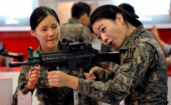 24일 경기도 일산 킨텍스에서 개최된 대한민국 방위산업전(DX Korea 2014)에서 여군들이 국내 방산업체인 S&T모티브가 개발한 K2C 소총을 살펴보고 있다. 손형준기자 boltagoo@seoul.co.kr  