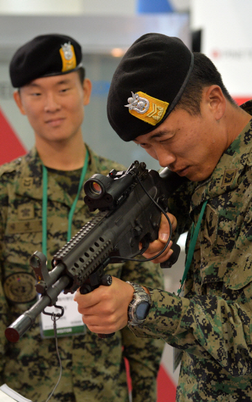 24일 경기도 일산 킨텍스에서 개최된 대한민국 방위산업전(DX Korea 2014)에서 특전사 대원들이 국내 방산업체인 S&T모티브가 개발한 K2C 소총을 살펴보고 있다. 손형준기자 boltagoo@seoul.co.kr  