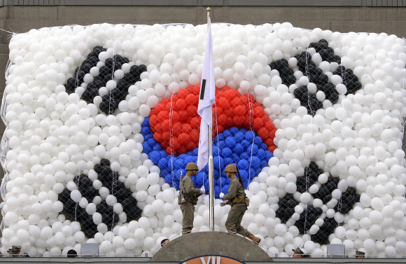 28일 제64주년 서울수복 기념행사에서 해병대병사들이 태극기를 게양하고 있다.