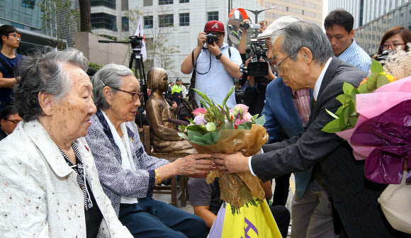 1일 서울 종로구 일본대사관 앞에서 열린 제1146차 정기 수요집회에서 한일교회협의회 소속 시다 도시츠구(맨 오른쪽) 목사가 위안부 피해 할머니에게 사과의 꽃다발을 전하고 있다.  연합뉴스