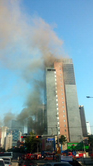 9일 오전 서울 중구 충무로 한 호텔 신축공사현장에서 불이나 검은 연기가 하늘로 치솟고 있다.  연합뉴스