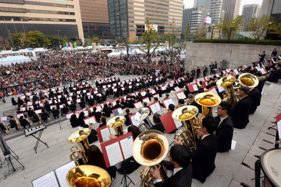 시민 예술가로 구성된 ‘600인의 윈드 오케스트라’가 19일 서울 종로구 세종문화회관 중앙계단에서 시민들에게 아름다운 하모니를 선사하고 있다. 이언탁 기자 utl@seoul.co.kr