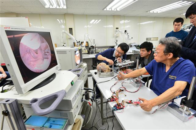 2일 서울 서대문구 연세대 세브란스병원 임상의학연구센터에서 김선호(오른쪽) 교수가 미세수술용 로봇을 이용, 실험용 시체(카데바)에서 뇌하수체 종양을 제거하는 수술을 시연하고 있다. KIST 제공