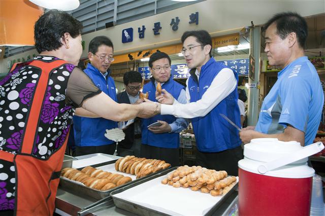 2011년 8월 이재용(맨 오른쪽) 당시 삼성전자 사장이 경기 수원 팔달문시장을 돌면서 상인들에게 미소금융 안내문을 나눠 주고 있다. 삼성그룹 제공