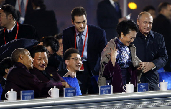 아시아태평양경제협력체(APEC) 정상회의 참석차 베이징(北京)을 방문한 블라디미르 푸틴 러시아 대통령이 저녁 야외 행사에서 중국의 ‘퍼스트레이디’인 펑리위안(彭麗媛)의 왼쪽에 서서 담요 1장을 어깨에 덮어 주고 있다. AP/뉴시스