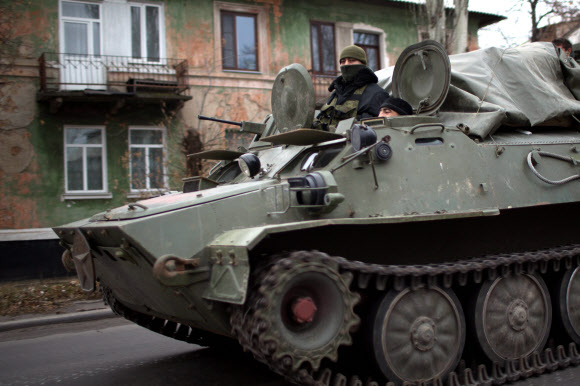 12일(현지시간) 친러시아 반군이 장악한 우크라이나 동부 도네츠크의 한 주요 도로에 중무장한 장갑차가 지나가고 있다. 북대서양조약기구(나토)는 이날 “러시아의 탱크 및 전투병력이 우크라이나에 진입했다”고 주장했고, 러시아는 이를 부인했다.  도네츠크 AFP 연합뉴스 
