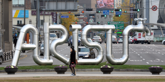 17일 서울광장 앞 교통섬에 설치된 서울의 수돗물 아리수 조형물 앞을 시민들이 지나가고 있다. 상수도관을 이용해 만들어진 이 조형물은 내년 서울 전역에 고도 정수처리된 수돗물이 공급되는 것을 기념하기 위해 서울시가 설치했다.  손형준 기자 boltagoo@seoul.co.kr