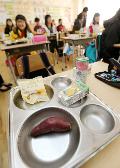 전국 학교비정규직 노동자들이 총파업에 돌입한 20일 오후 급식에 차질이 생긴 대구의 한 초등학교에서 학생들이 대체급식으로 나온 빵과 고구마를 먹고 있다.  연합뉴스