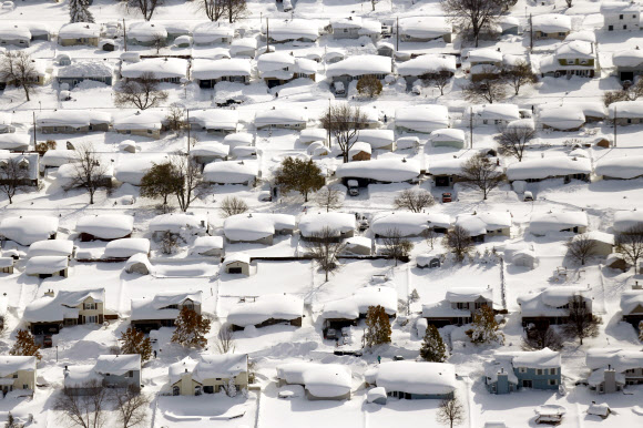 19일(현지시간) 미국 뉴욕주 북부 웨스트세네카의 주택가가 눈폭풍이 몰고 온 폭설에 파묻혀 있다. 나이아가라 폭포와 가까운 버팔로시 주변은 이른바 ‘호수효과’에 기인한 폭설로 만 하루 만에 1.5m가 넘는 기록적인 적설량을 기록했다. 기상 당국은 앞으로 60~100㎝의 눈이 더 내릴 것으로 예보했다. 38년 만의 기록적인 11월 한파와 폭설로 지난 15일 이후 미 전역에서 모두 20여명의 인명피해가 발생했다.  웨스트세네카 AP 연합뉴스