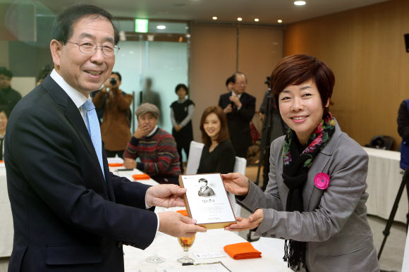 방송인 김미화가 25일 오전 서울시청에서 열린 ’민선6기 서울시 홍보대사 위촉식’에서 박원순 서울시장으로부터 위촉패를 받고 있다. 연합뉴스