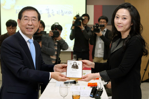 배우 김나운이 25일 오전 서울시청에서 열린 ’민선6기 서울시 홍보대사 위촉식’에서 박원순 서울시장으로부터 위촉패를 받고 있다.  연합뉴스