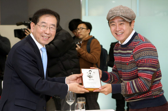 배우 이광기가 25일 오전 서울시청에서 열린 ’민선6기 서울시 홍보대사 위촉식’에서 박원순 서울시장으로부터 위촉패를 받고 있다. 연합뉴스