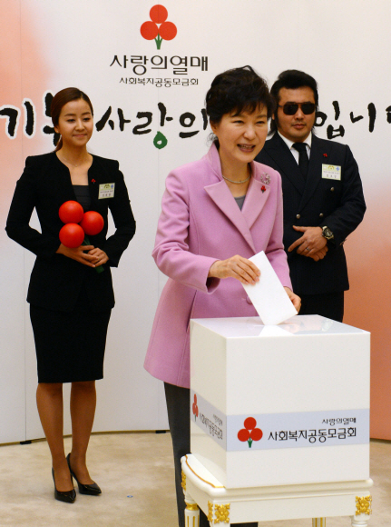 박근혜 대통령이 28일 오후 청와대에서 열린 ’사랑의 열매’ 전달식에서 성금함에 성금을 넣고 있다. 왼쪽은 사랑의 열매 홍보대사인 방송인 전제향, 오른쪽은 배우 김보성. 안주영 기자 jya@seoul.co.kr