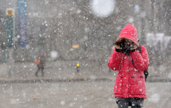 전국적으로 강풍을 동반한 눈이 내린 1일 오전 한 시민이 서울 광화문 사거리를 지나고 있다. 도준석 기자 pado@seoul.co.kr