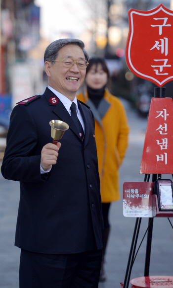 이수근 사무총장이 지난 22일 서울 종로구 새문안로 자선냄비 모금함 앞에서 희망을 부르는 종을 치고 있다. 자선냄비 모금은 31일로 마감된다.  이언탁 기자 utl@seoul.co.kr