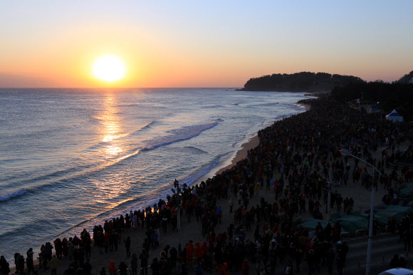 1일 새벽 속초해변을 찾은 수많은 해맞이 인파가 수평선 위로 떠오르는 태양을 맞이하고 있다.  연합뉴스