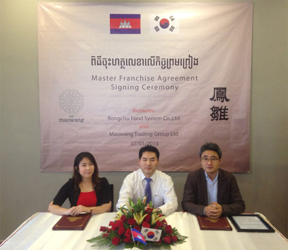 봉추푸드시스템 장준수대표(오른쪽)는 캄보디아 프놈펜에서 마오왕 트레이닝 그룹의 피치모리카 프라크(Pichmolika Prak) 대표(왼쪽)와 마스터 프랜차이즈 계약을 맺었다.