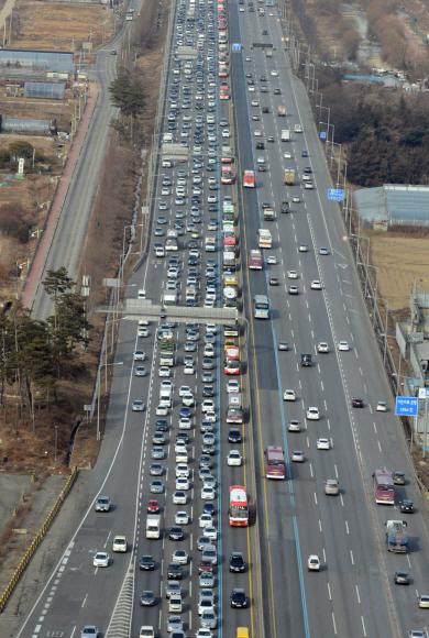 2014년 1월 설날 하루 전 경부고속도로 신갈나들목 부근에 주차장을 이룬 귀성 차량들. 서울로 몰려든 사람들은 매년 명절 때면 고향으로 민족 대이동을 반복하고 있다. 도준석기자 pado@seoul.co.kr