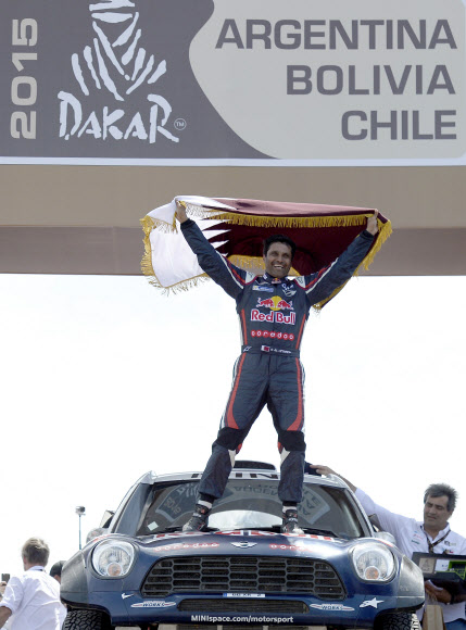 카타르의 나세르 알 아티야가 18일 아르헨티나 부에노스아이레스에서 막을 내린 ‘죽음의 경주’ 2015 다카르 랠리 자동차 부문에서 우승한 뒤 자동차 위에서 국기를 흔들며 기뻐하고 있다. 부에노스아이레스 AFP 연합뉴스