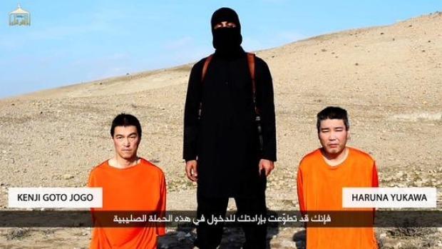 20일 이슬람국가(IS)의 미디어 조직 알푸르칸이 공개한 영상에서 복면을 뒤집어쓴 IS 요원이 일본인 고토 겐지(왼쪽), 유카와 하루나(오른쪽) 가운데 서서 3일 이내에 몸값 2억 달러를 내지 않으면 이들을 죽이겠다고 협박하고 있다. 알푸르칸 화면 캡처