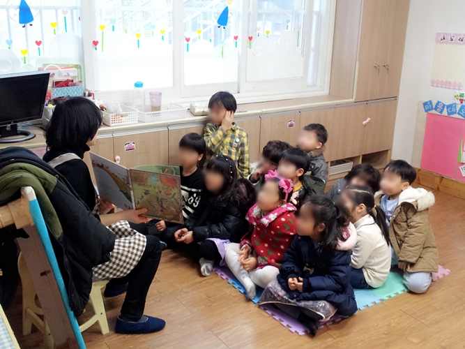 지난 6일 서울 강서구의 한 어린이집에서 보육교사가 아이들에게 동화를 읽어주고 있다.