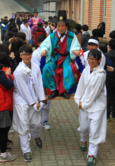 전통의상을 입은 충북 증평군 형석고등학교 학생들이 11일 교사를 태운 가마를 들고 졸업식장에 들어서고 있다. 증평 연합뉴스