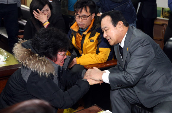 이완구 국무총리가 22일 오후 경기도 안산시 화랑유원지에 마련된 세월호 참사 희생자 합동분향소를 조문한 뒤 열린 유가족과의 간담회에서 세월호의 조속한 인양을 호소하며 무릎 꿇고 오열하는 한 실종자 가족을 위로하고 있다.  연합뉴스