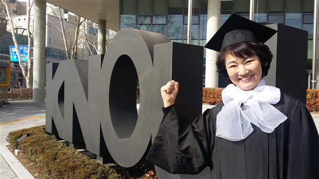 암을 이겨 내고 한국방송통신대를 졸업한 이지연씨가 24일 서울 종로구 동숭동 대학 앞에서 주먹을 쥐며 활짝 웃고 있다.