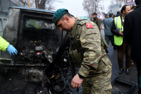 26일 아프가니스탄 수도 카불에 위치한 이란 대사관사 앞에서 터키 대사관 차량을 겨냥한 자폭테러가 발생한 가운데 아프간 경찰들이 테러현장을 살피고 있다.  ⓒAFPBBNews=News1