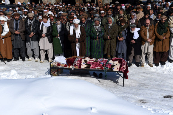 26일(현지시간) 폭설로 인한 눈사태가 일어난 아프가니스탄 수도 카불 북쪽 판지시르 주에서 아프간 남성들이 눈사태로 사망한 희생자들의 시신을 나르고 있다. ⓒAFPBBNews=News1