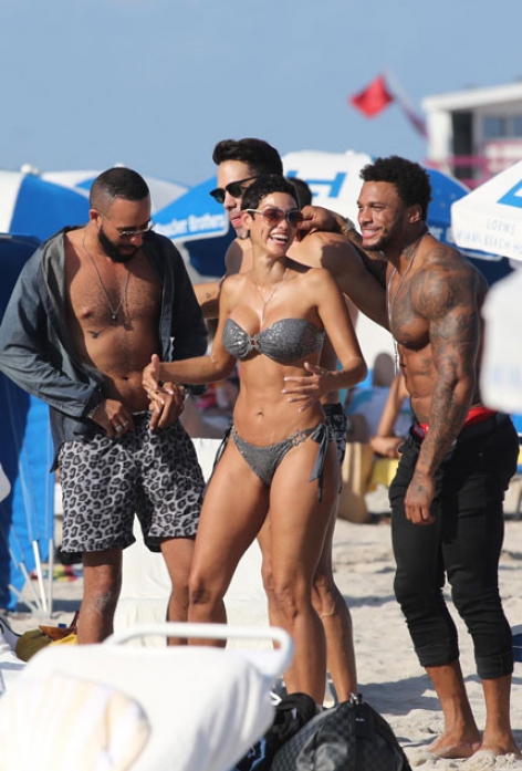 니콜 머피가 한뼘 비키니를 입고 마이애미해변에서 근육질 남성들이 둘러싸자 즐거워하고있다.<br>