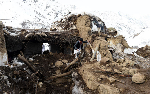 1일(현지시간) 아프가니스탄 북서부 판지시르 주의 한 마을에서 발생한 눈사태에서 살아남은 주민들이 무너진 건물 속을 수색하고 있다. ⓒAFPBBNews=News1