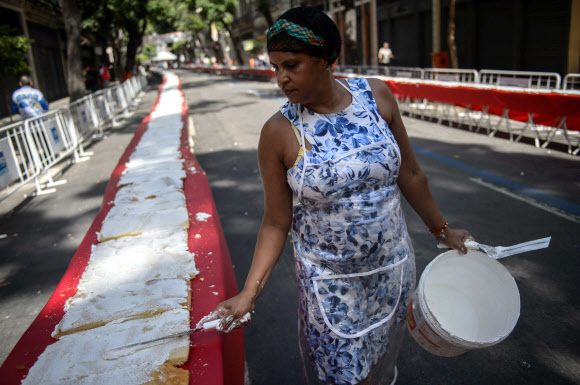 1일(현지시간) 브라질 리우데자네이루시 설립 450주년 기념축제가 열린 가운데 한 여성이 450m 길이의 U자 모양 케익을 만들고 있다.  ⓒAFPBBNews=News1