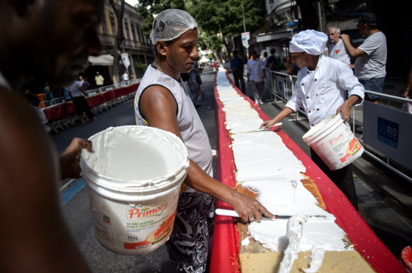 1일(현지시간) 브라질 리우데자네이루시 설립 450주년 기념축제가 열린 가운데 제빵사들이 450m 길이의 U자 모양 케익을 만들고 있다.  ⓒAFPBBNews=News1
