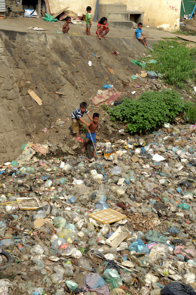 4일(현지시간) 캄보디아 프놈펜의 한 소년이 쓰레기로 가득 찬 운하에서 놀고 있다. ⓒAFPBBNews=News1