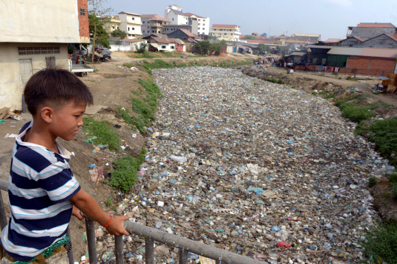 4일(현지시간) 캄보디아 프놈펜의 한 소년이 쓰레기로 가득 찬 운하를 내려다 보고 있다. ⓒAFPBBNews=News1
